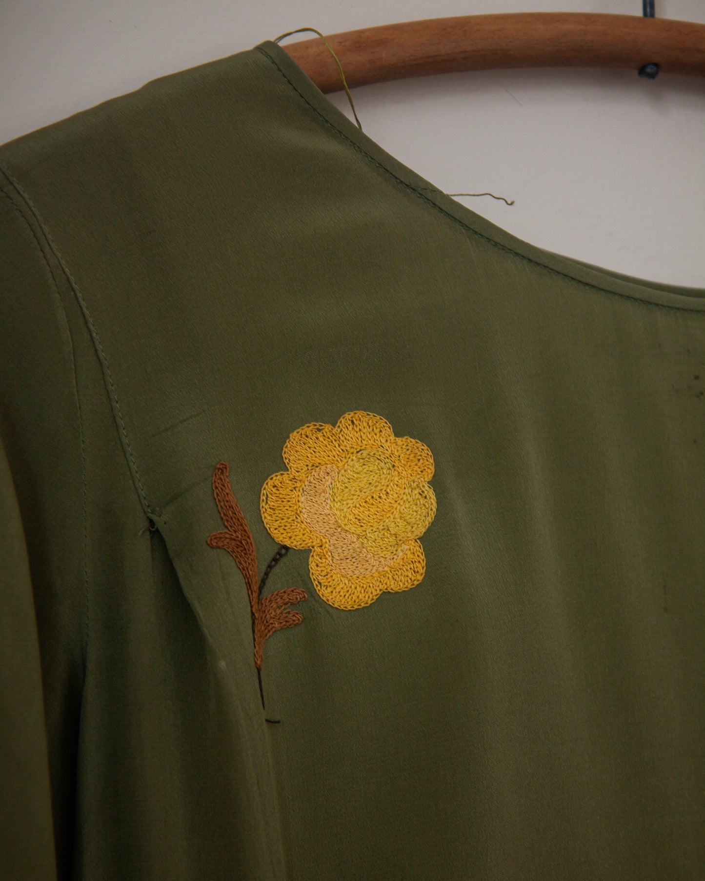 Green dress with a yellow flower embroidery on a white background