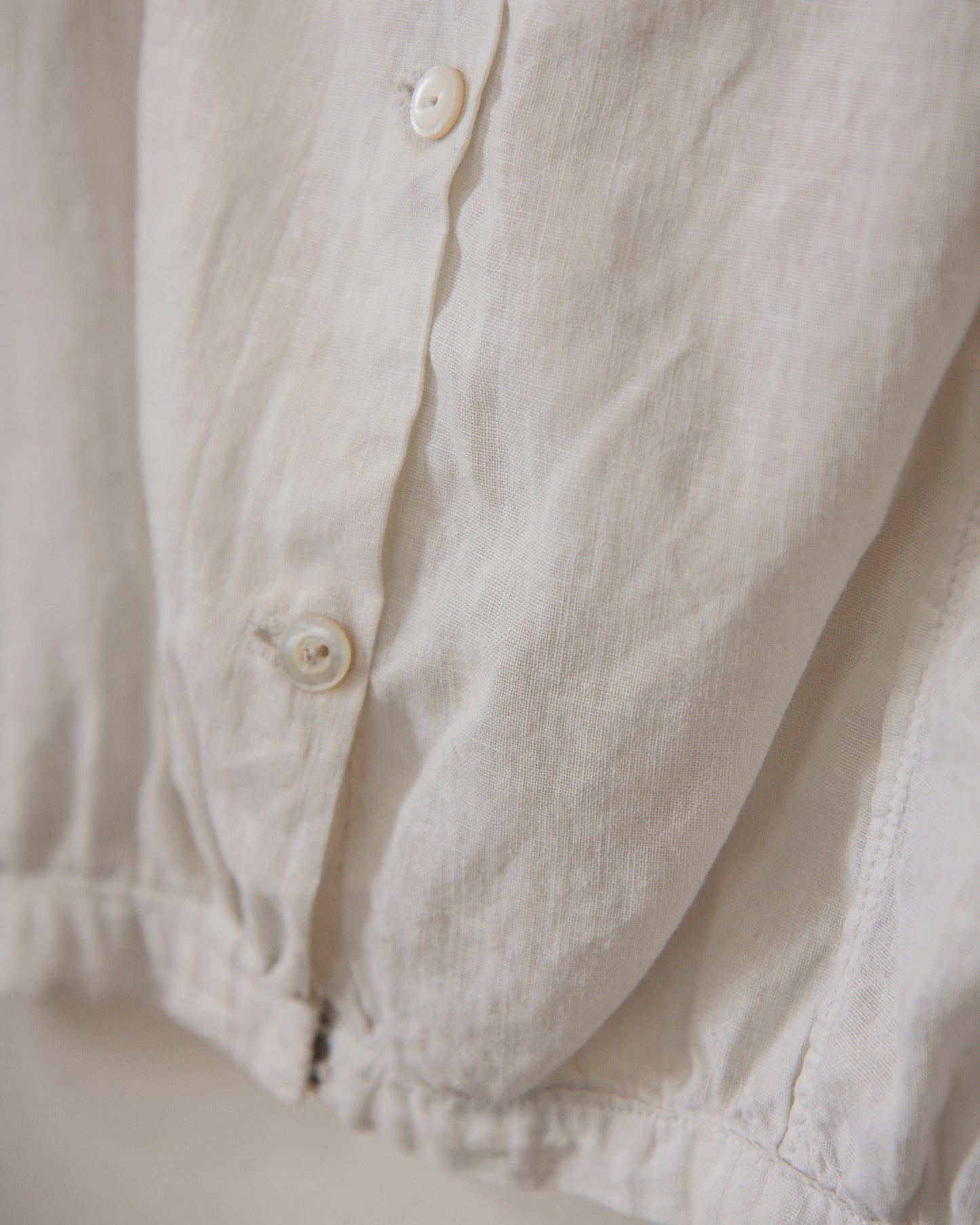 Close-up of a cream buttoned shirt with a soft focus background