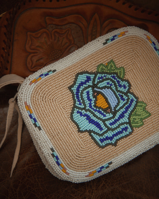 Beaded pouch with a floral design on a brown leather background