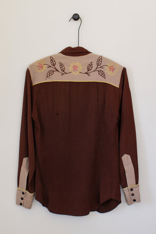 Brown shirt with embroidered details on a white background
