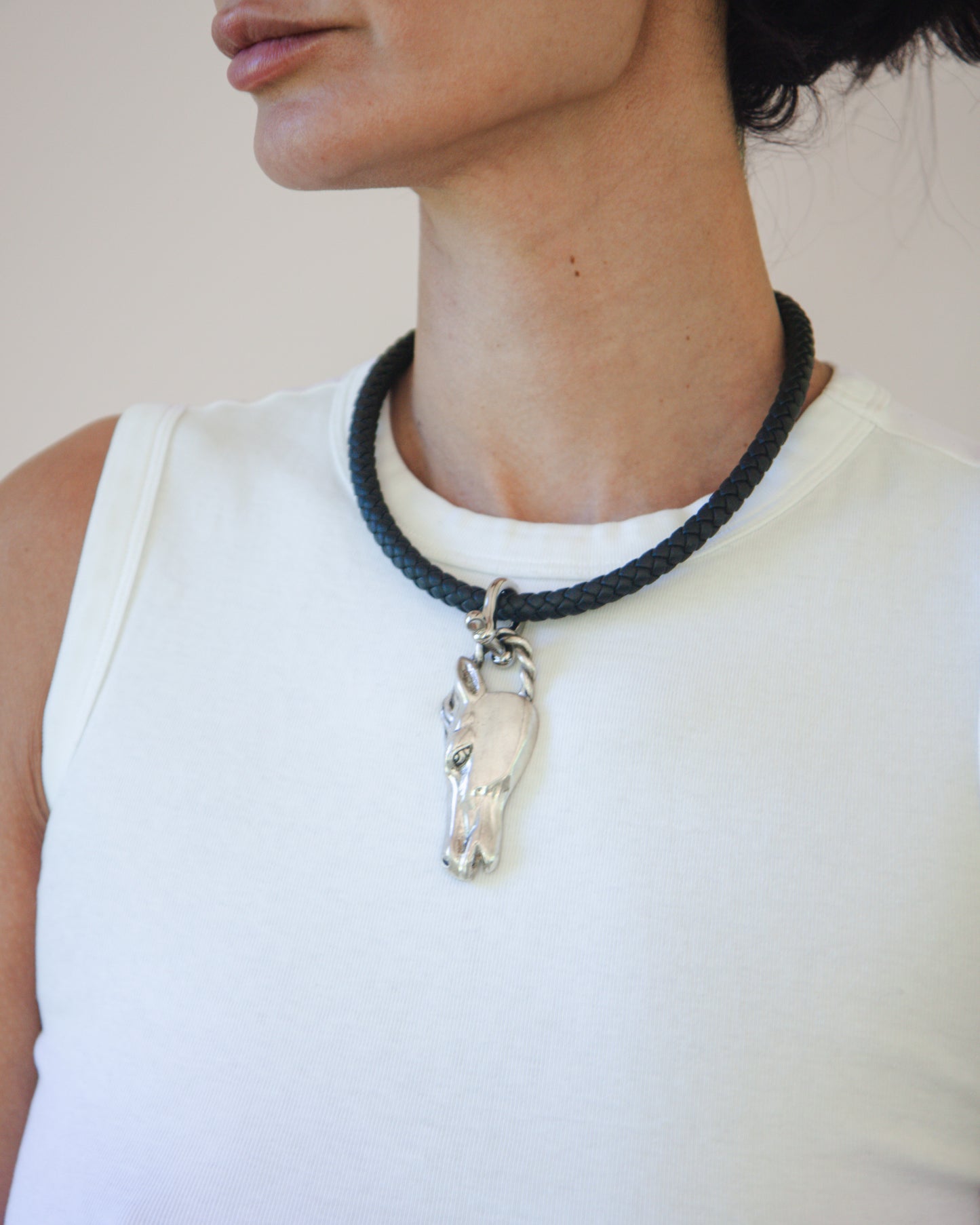 Woman wearing horse head pendant on black cord choker necklace