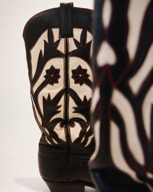 Black and white patterned cowboy boot on a light gray background