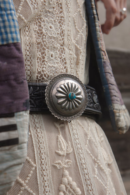 Close-up of a decorative belt buckle on a textured fabric background