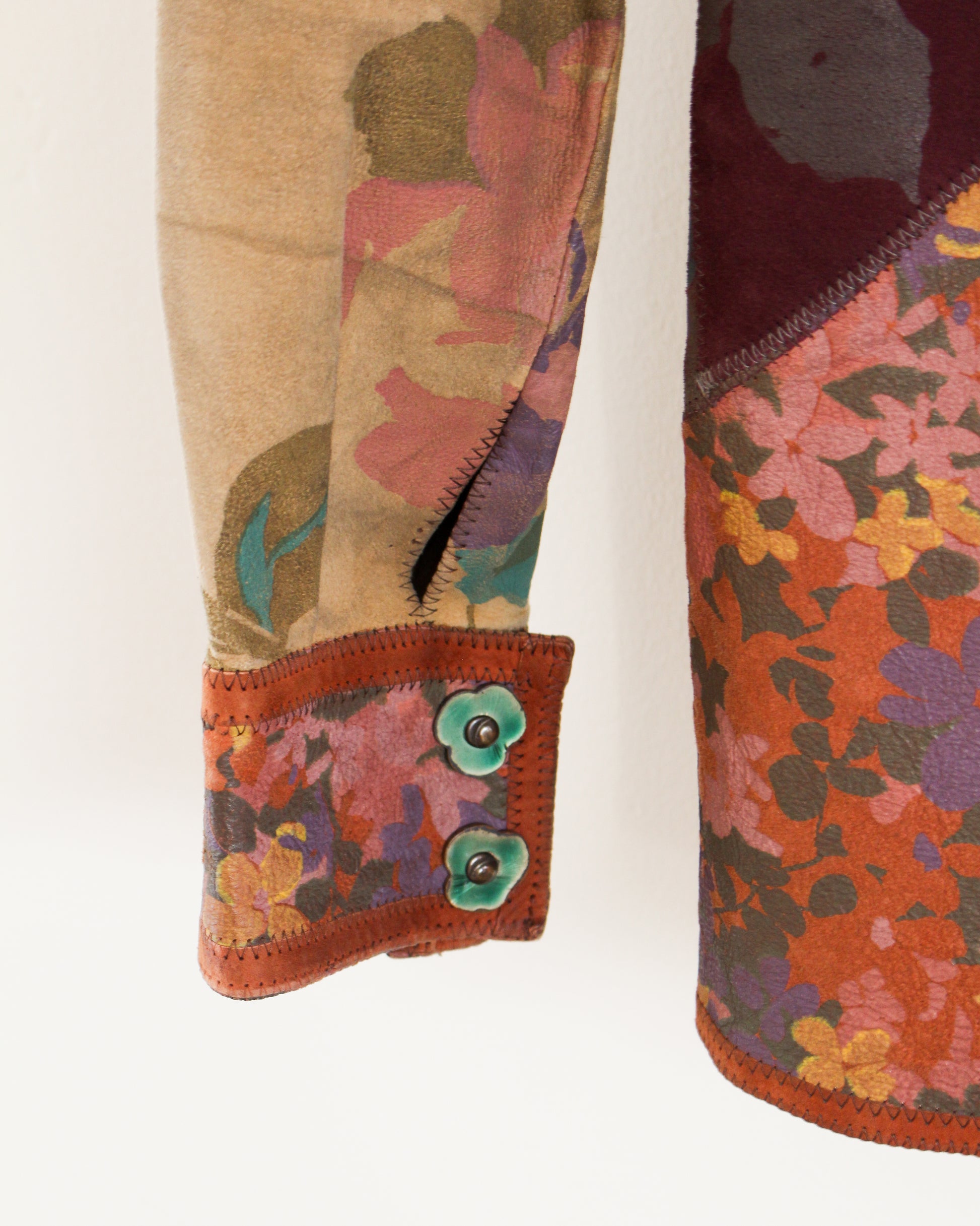 Close-up of colorful floral-patterned fabric with a button on a beige background