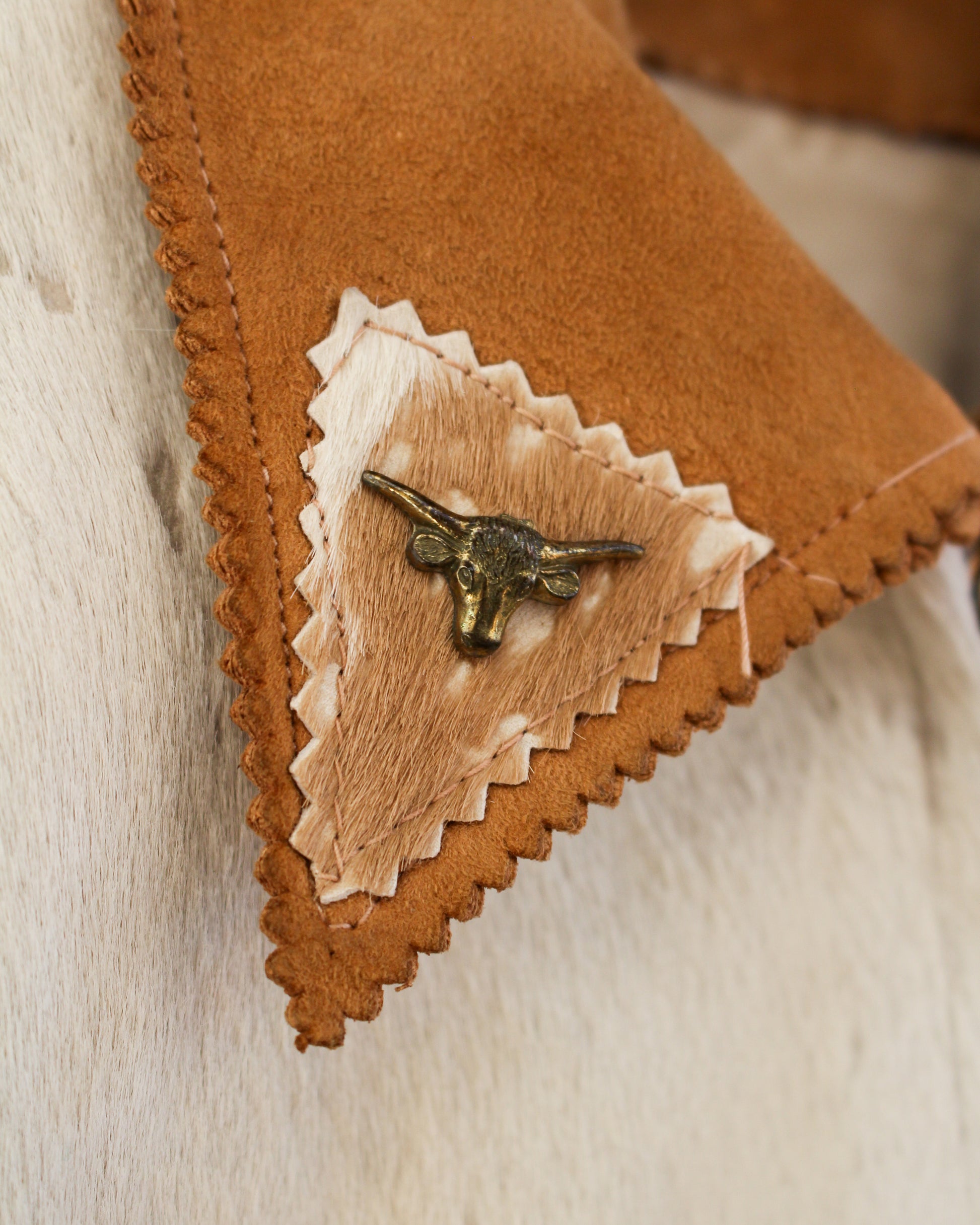 Close up of metal longhorn accent on collar of jacket