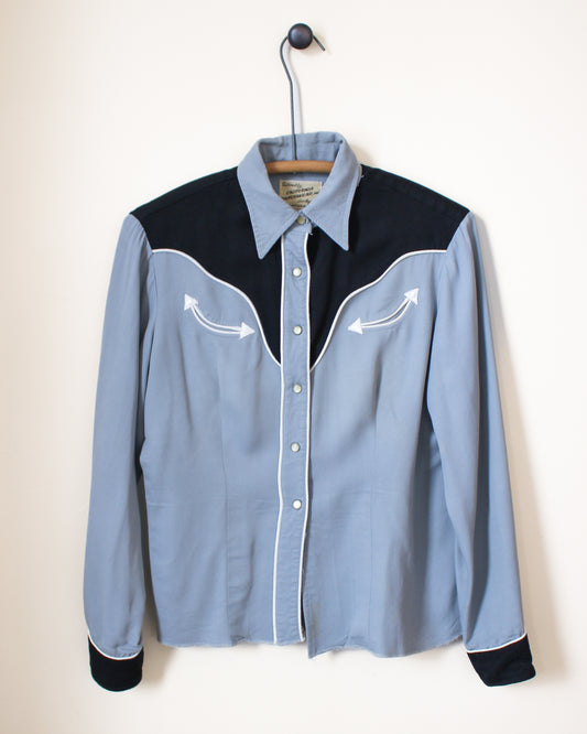 Blue and black button-up shirt on a hanger against a white background