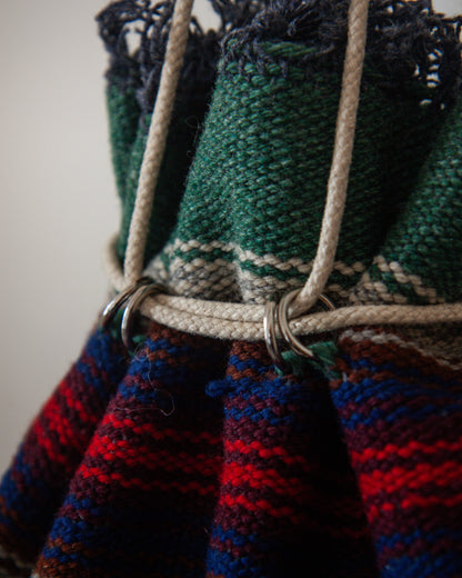 Close-up of a knitted bag with colorful patterns and a strap.