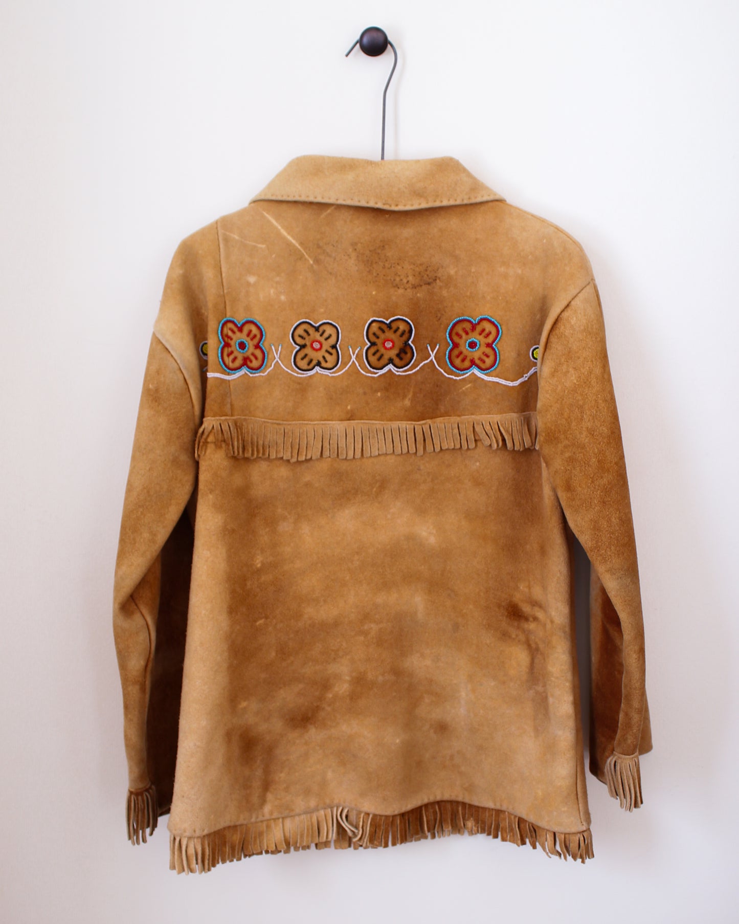 Brown suede jacket with floral embroidery and fringes on a white background