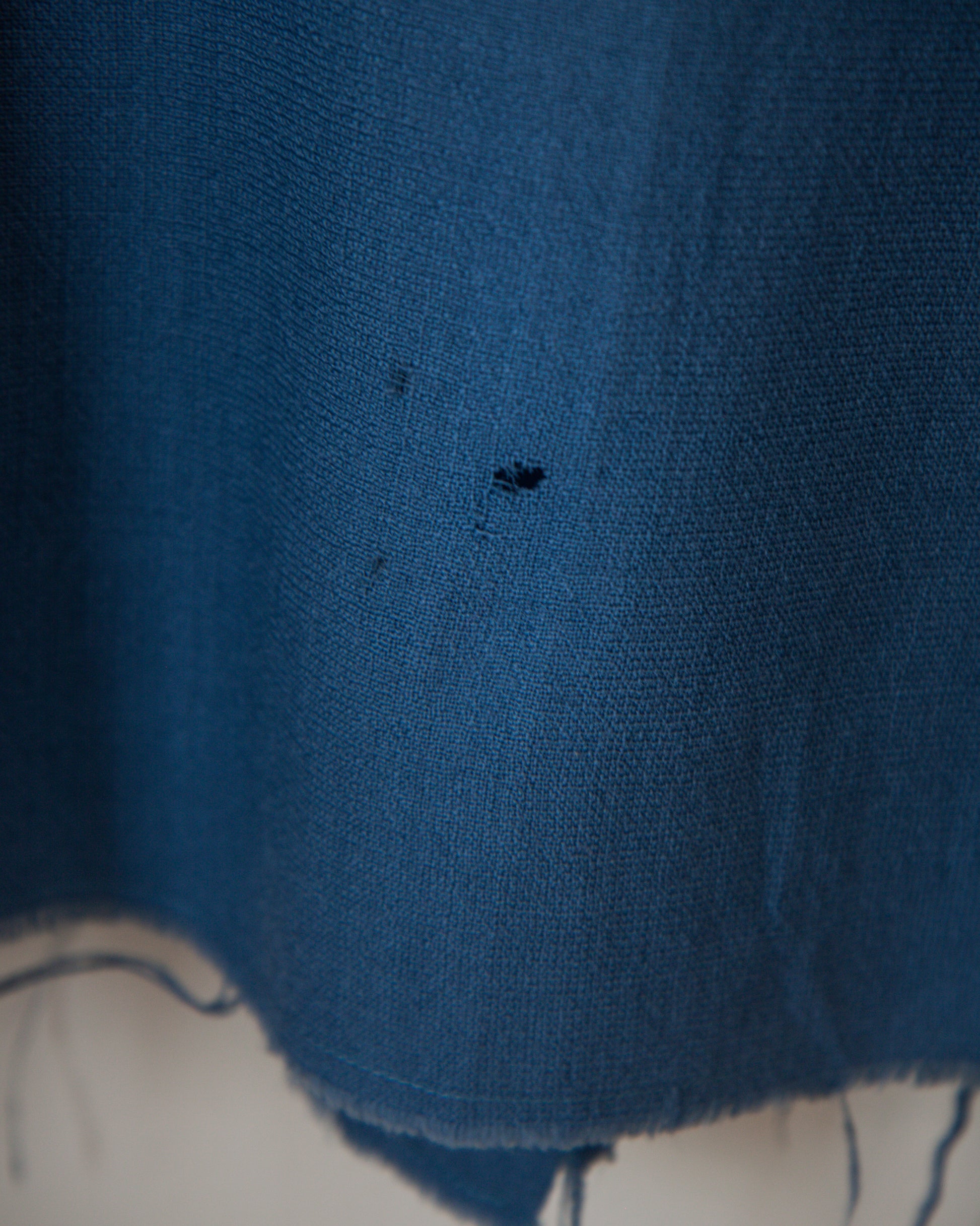 Close-up of a blue fabric with a small black mark