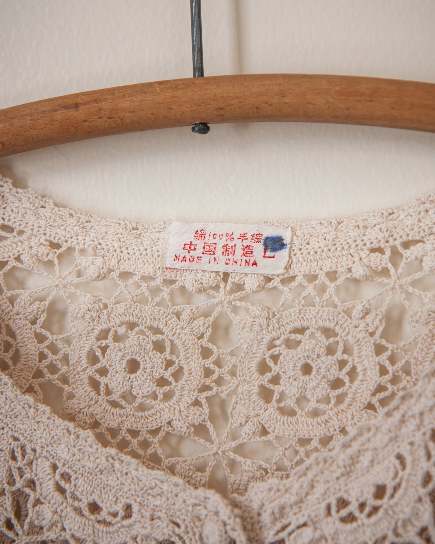 Lace fabric on a wooden hanger with a 'Made in China' label.
