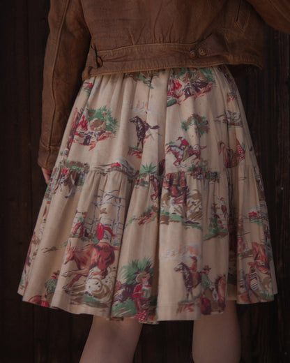 Skirt with vintage-style horse and rider pattern worn by a person in a brown jacket.