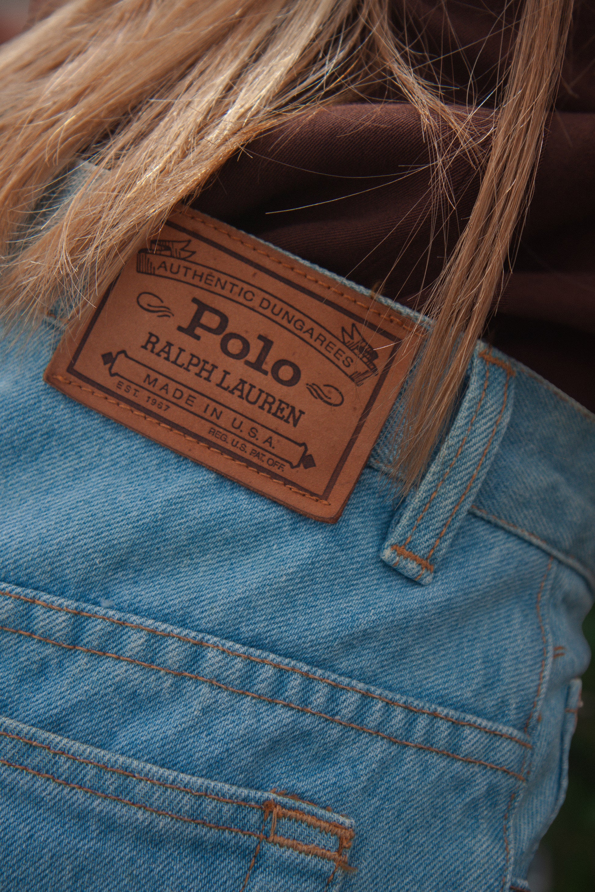 Close-up of a Polo Ralph Lauren label on blue denim skirt.