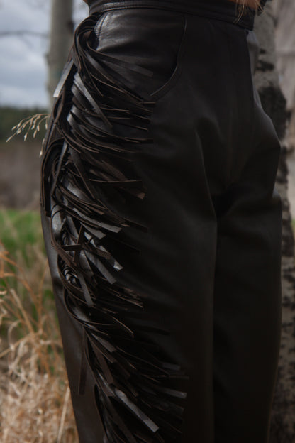 Black leather pants with decorative elements in a natural setting