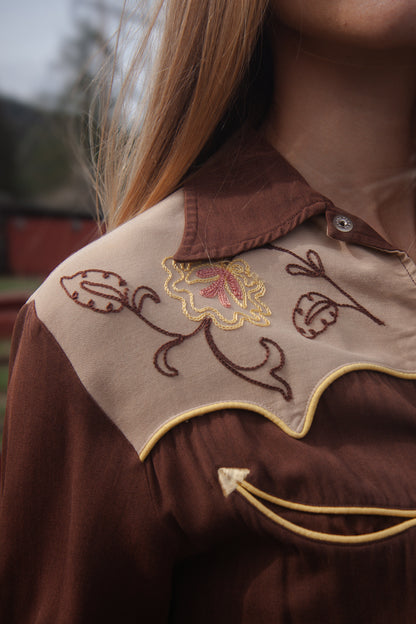 Close-up of a brown embroidered shirt with floral design