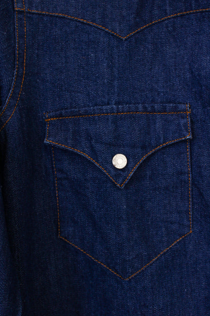 Close-up of a blue denim shirt pocket with a button.