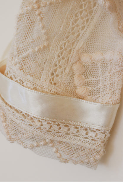 Close-up of lace fabric with a satin ribbon on a neutral background