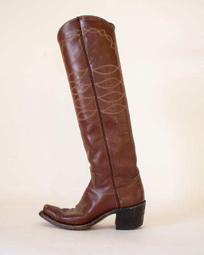 Brown leather boot with decorative pattern on a beige background