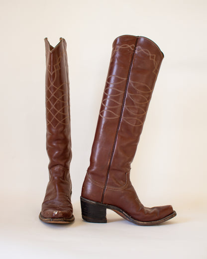 Pair of brown leather knee-high boots on a white background