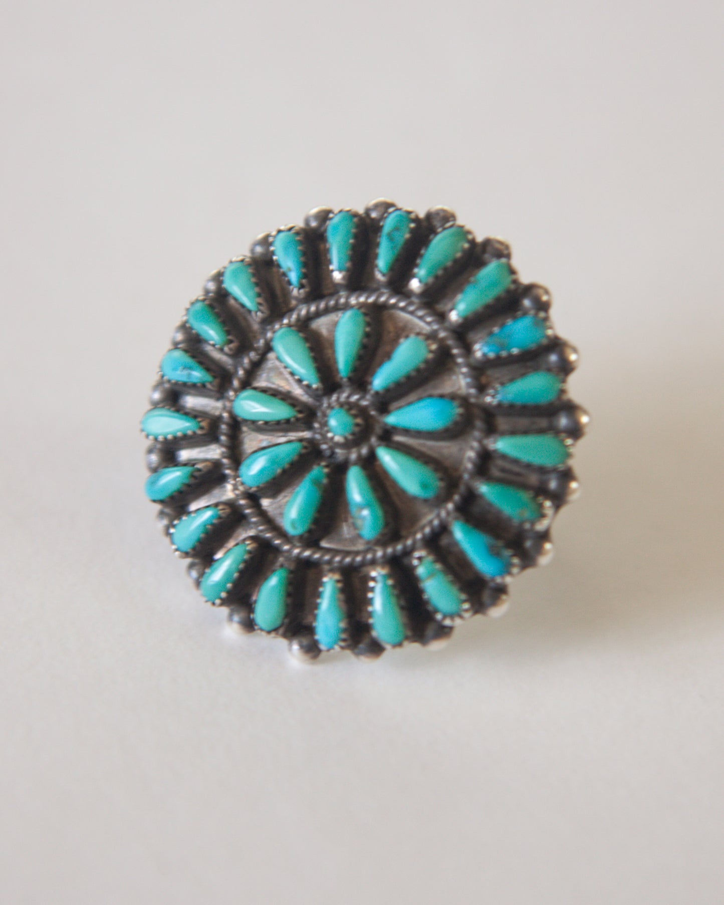 Turquoise and silver ring on a light gray background