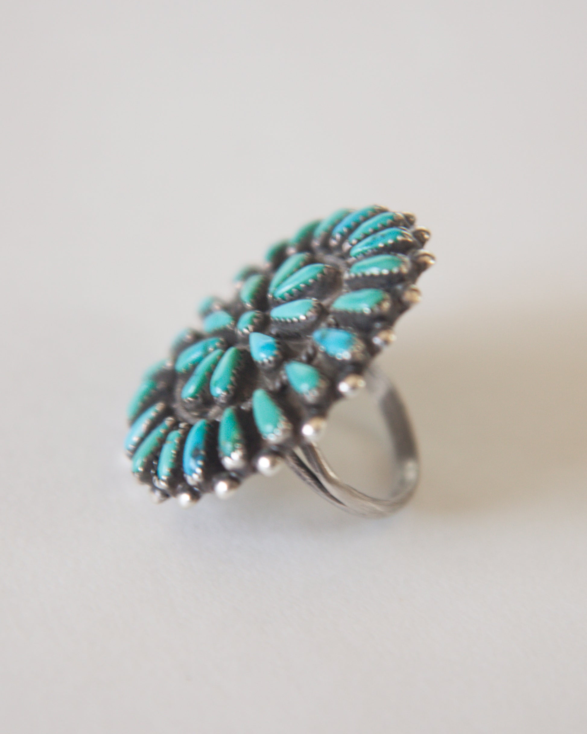 Turquoise ring with silver band on a light gray background