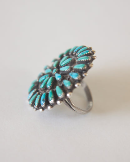 Turquoise ring with silver band on a light gray background