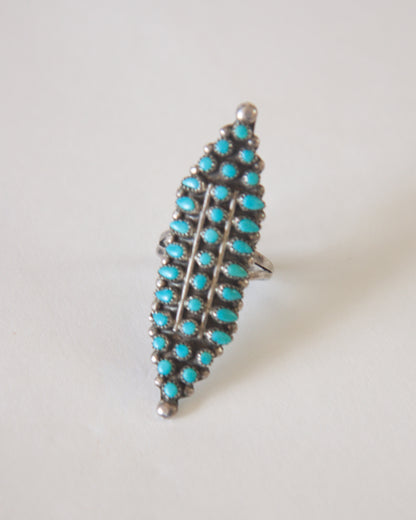 Turquoise ring with silver setting on a light gray background