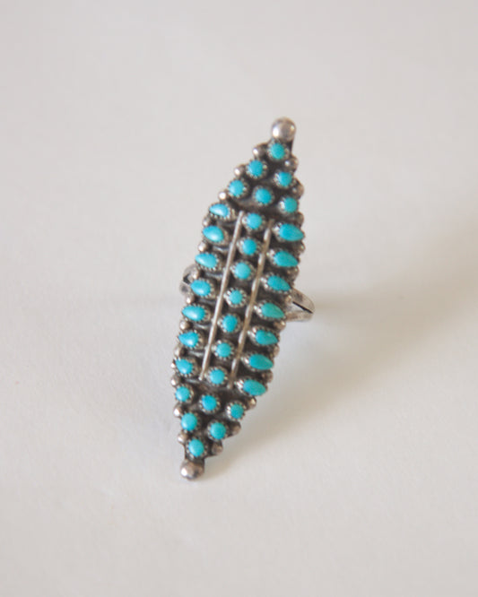 Turquoise ring with silver setting on a light gray background