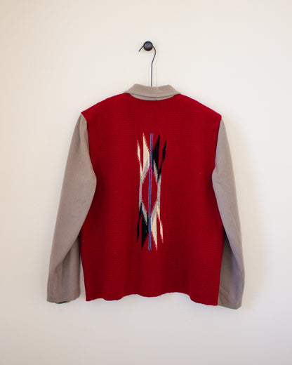 Red and tan jacket with a pattern on the back, hanging against a white background