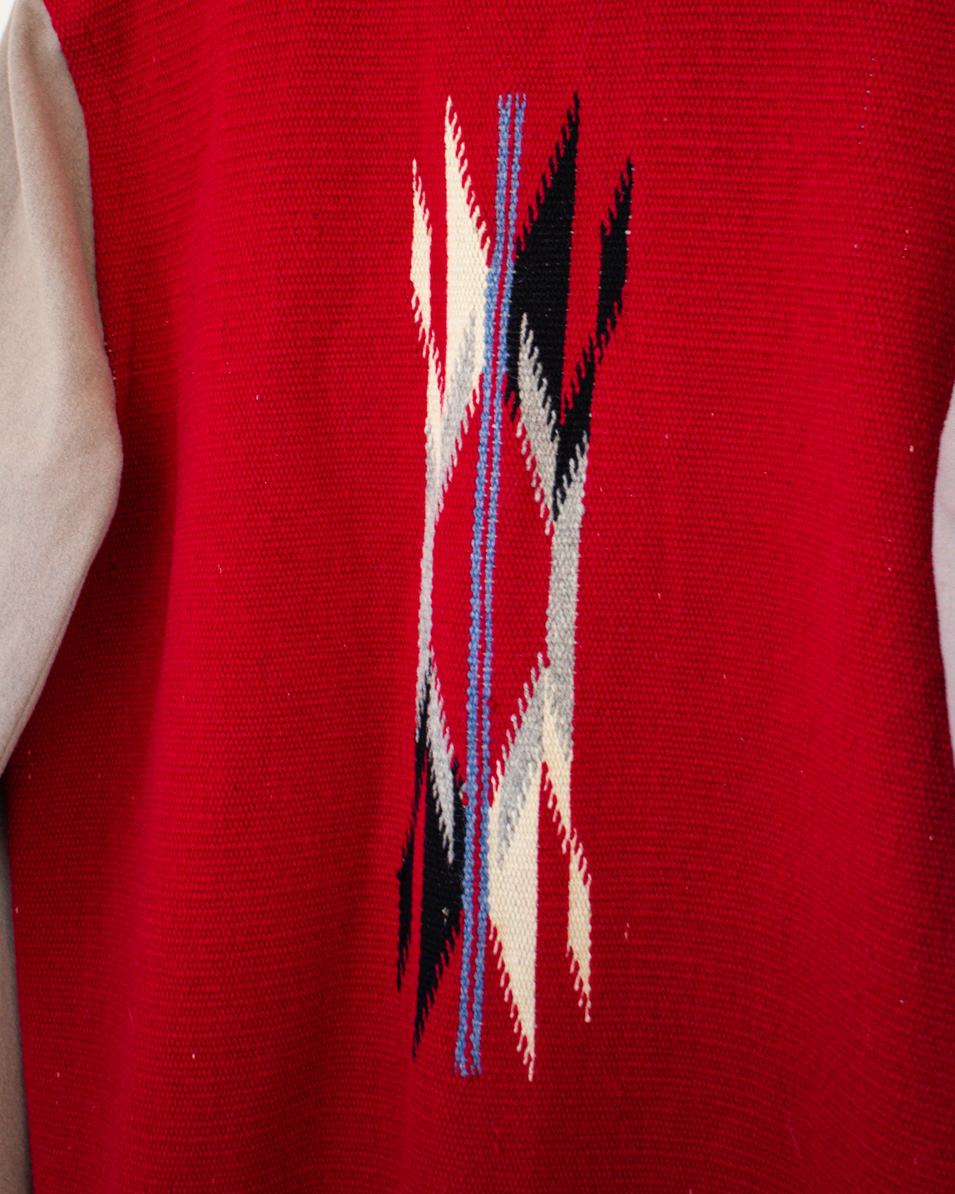 Red jacket with a geometric pattern featuring black, white, and blue lines.