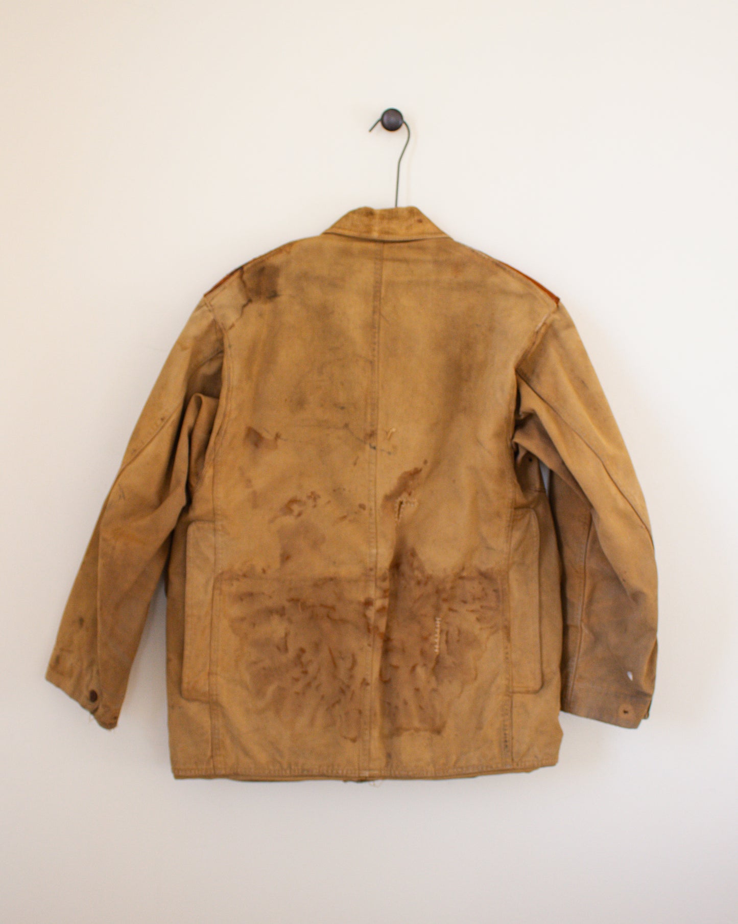 Brown canvas jacket with visible wear on a white background