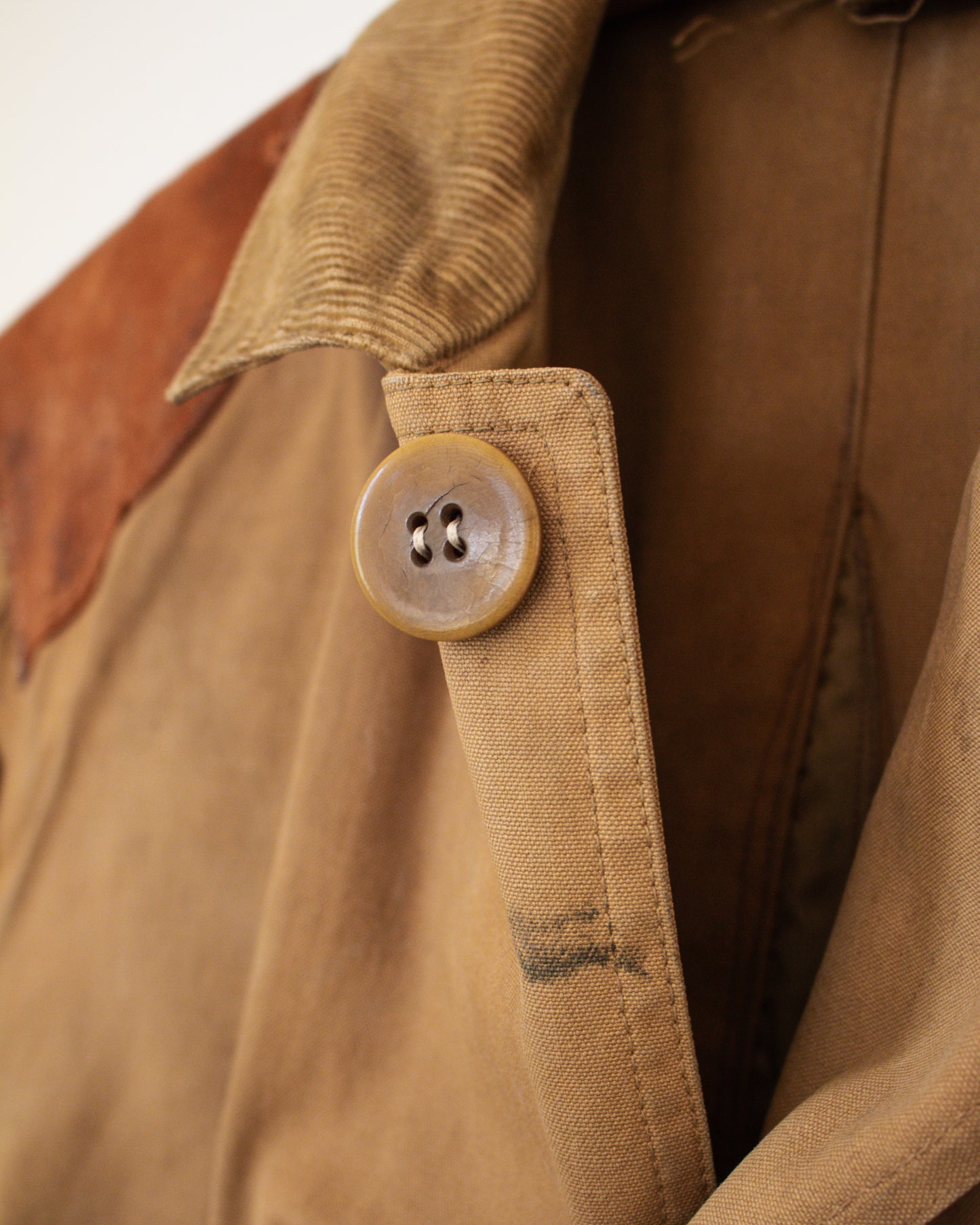 Close-up of a brown canvas jacket with a button