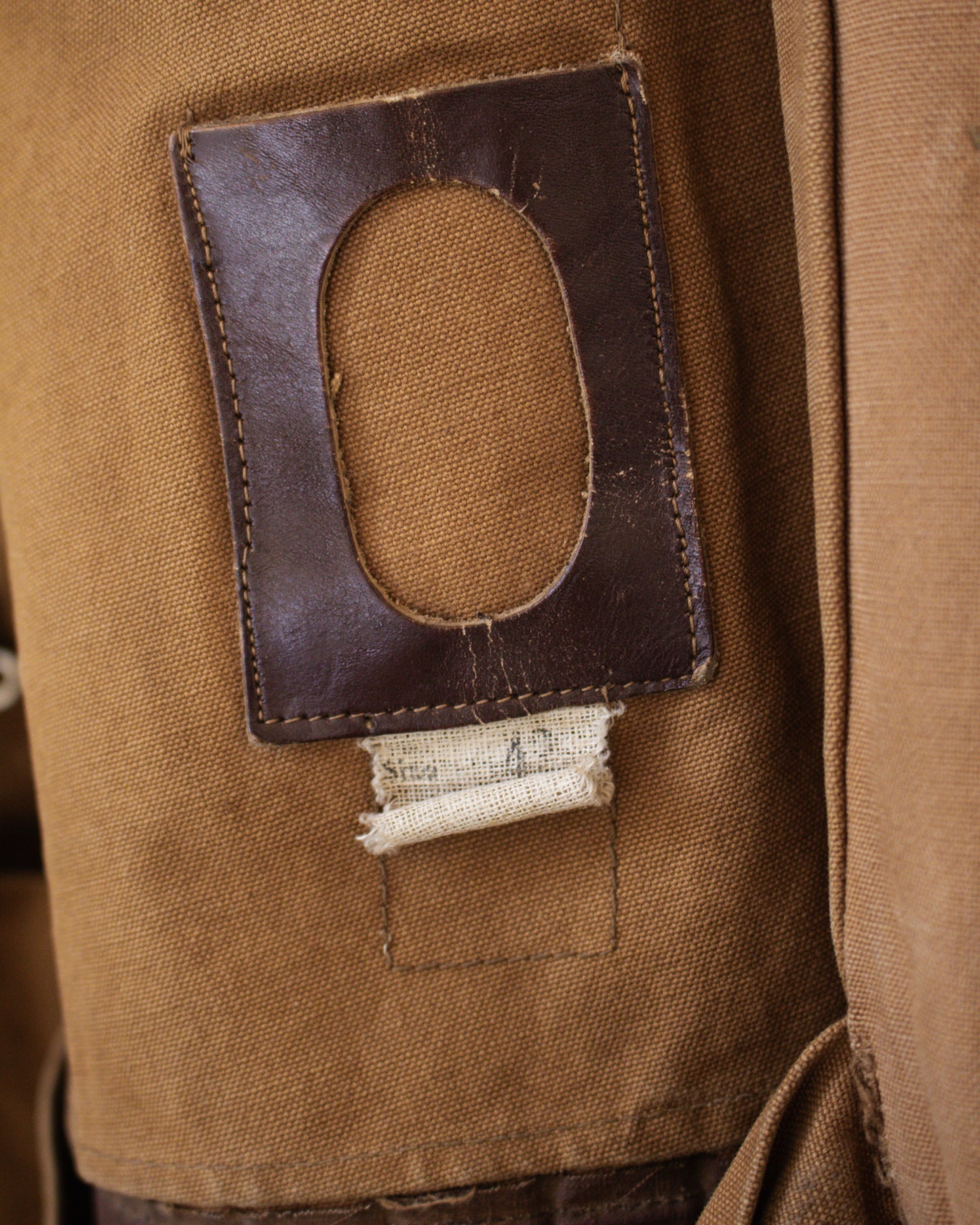 Close-up of a brown fabric patch with a rectangular cutout inside jacket