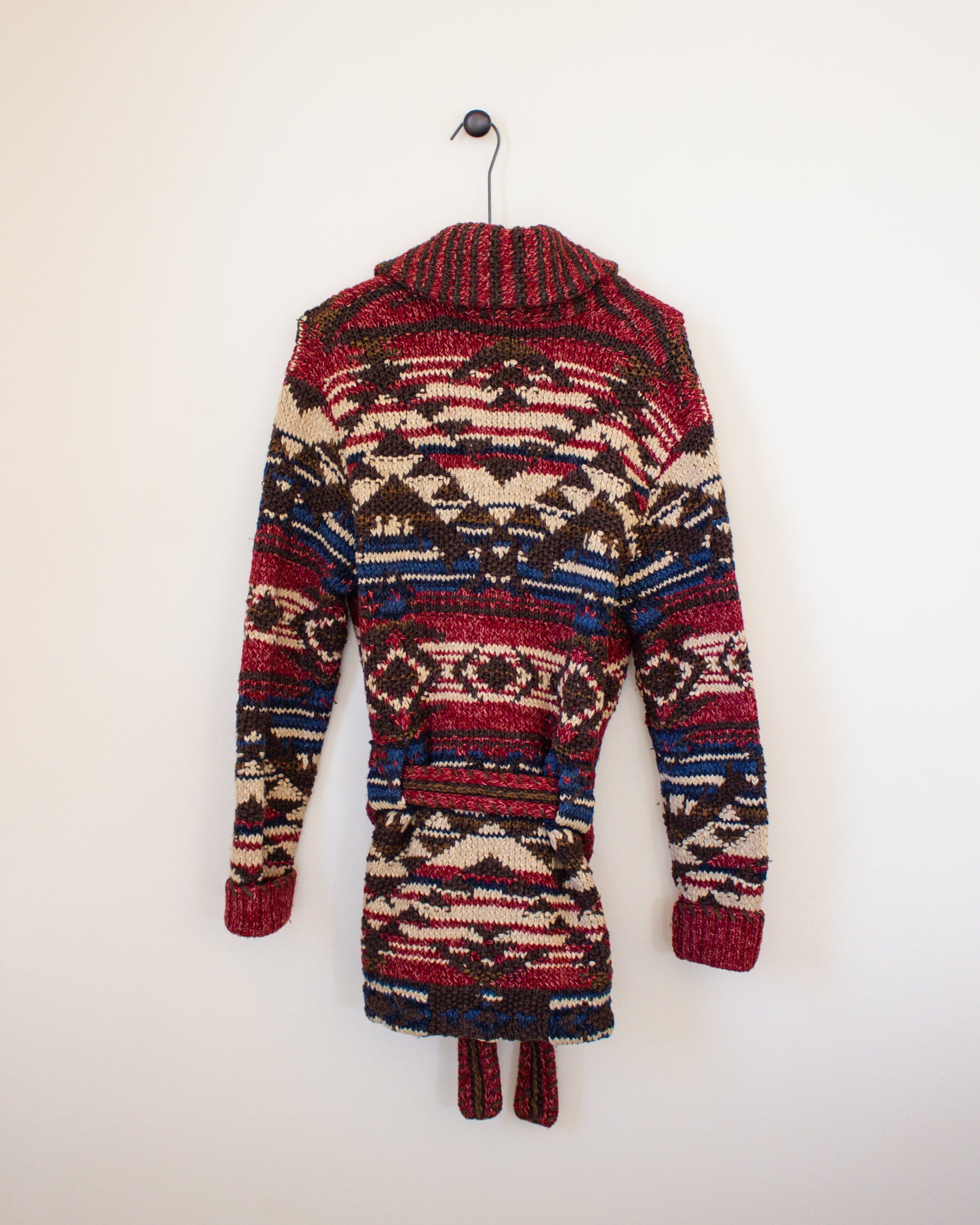 Colorful patterned jacket on a hanger against a white background - back view