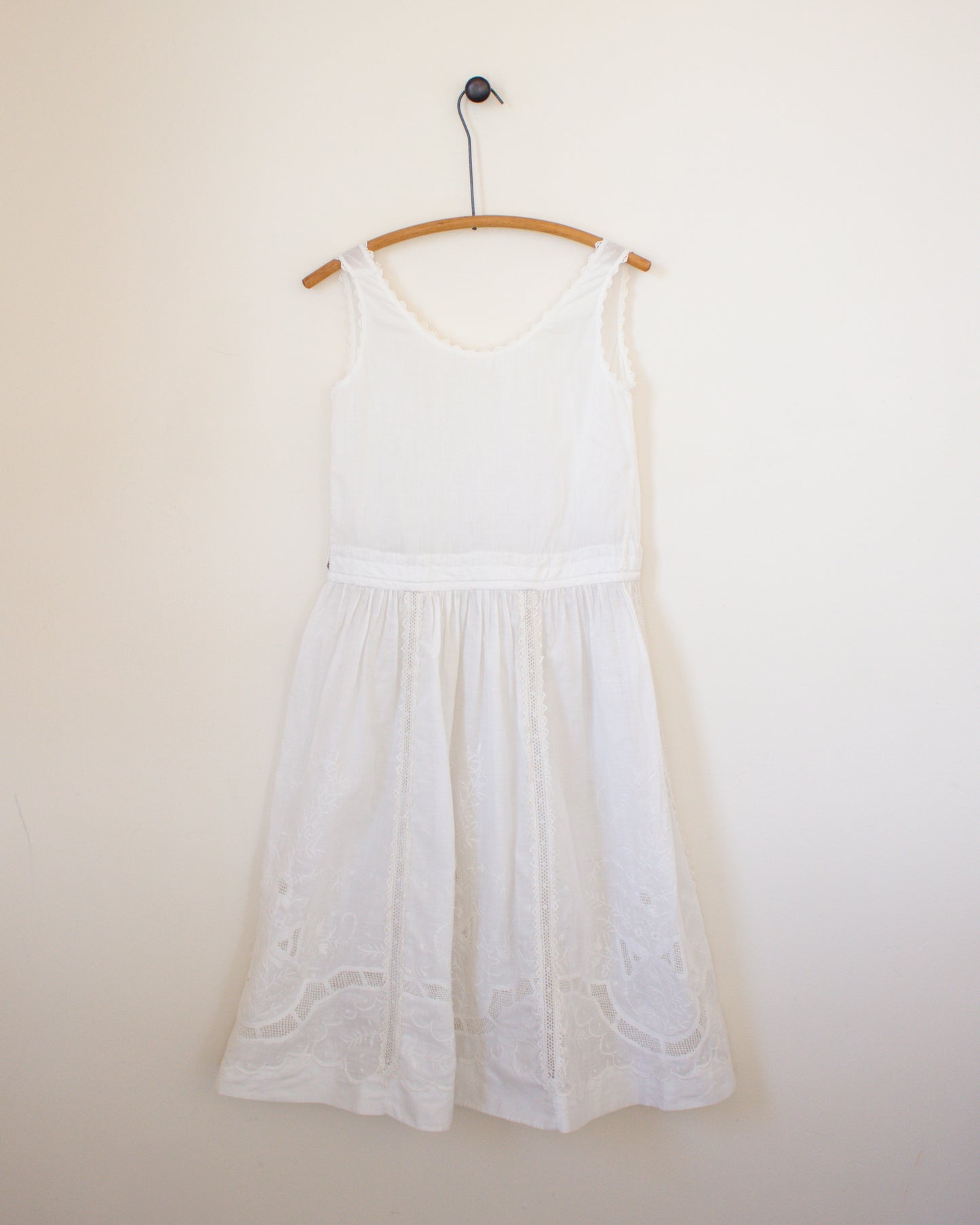 White dress on a hanger against a plain wall