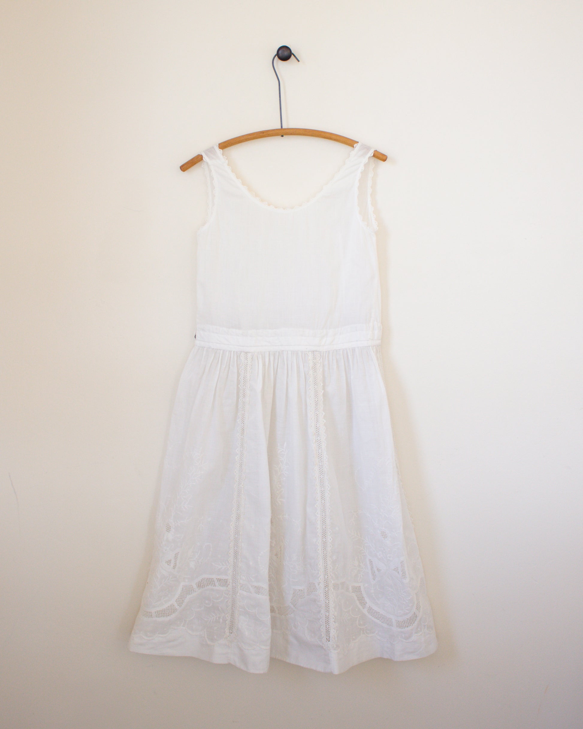 White dress on a hanger against a plain wall