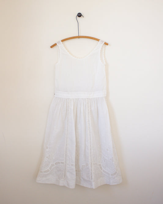 White dress on a hanger against a plain wall