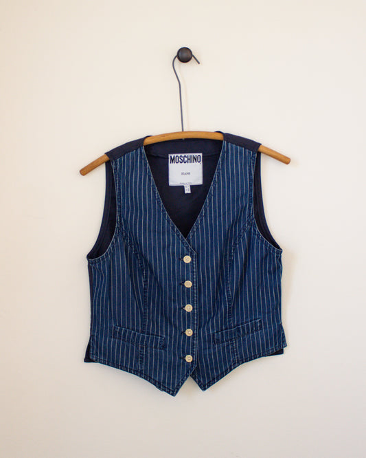 Blue pinstripe vest on a hanger with a visible Moschino label against a beige background