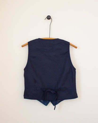 Navy blue sleeveless top with a tie detail on a beige background