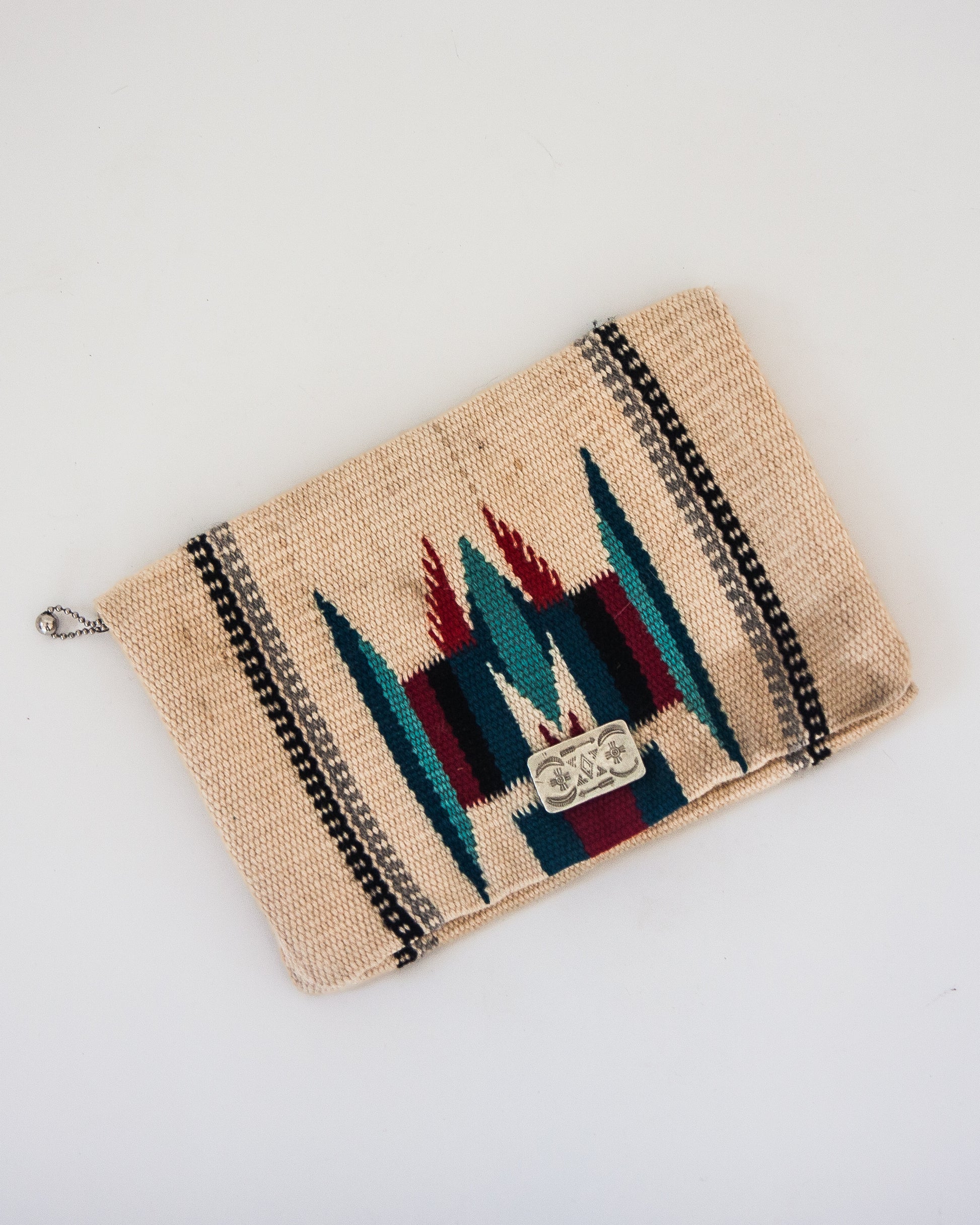Front view of vintage cream wool Chimayo clutch with turquoise, red, and brown/gray accents and silver front button clasp. 