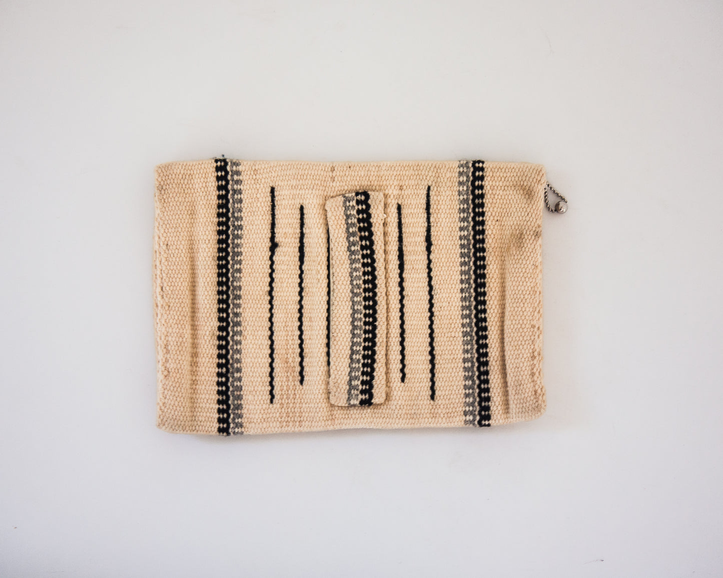 Back view of cream wool Chimayo clutch with hand strap in back. Gray and brown stripes. 