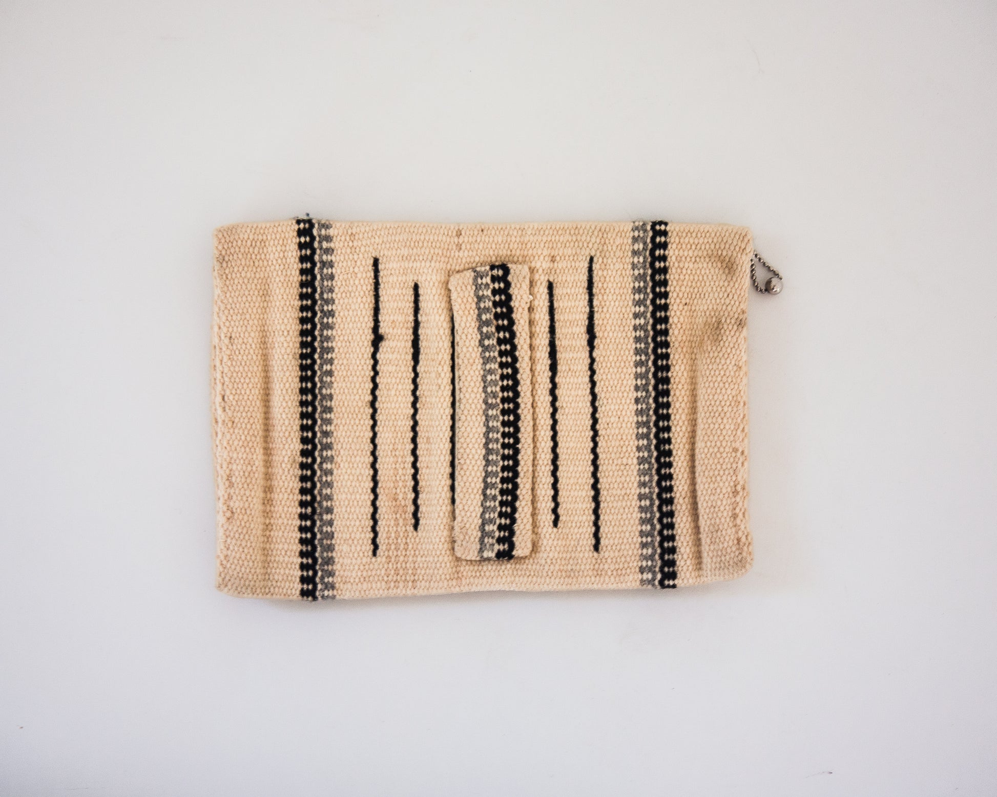 Back view of cream wool Chimayo clutch with hand strap in back. Gray and brown stripes. 