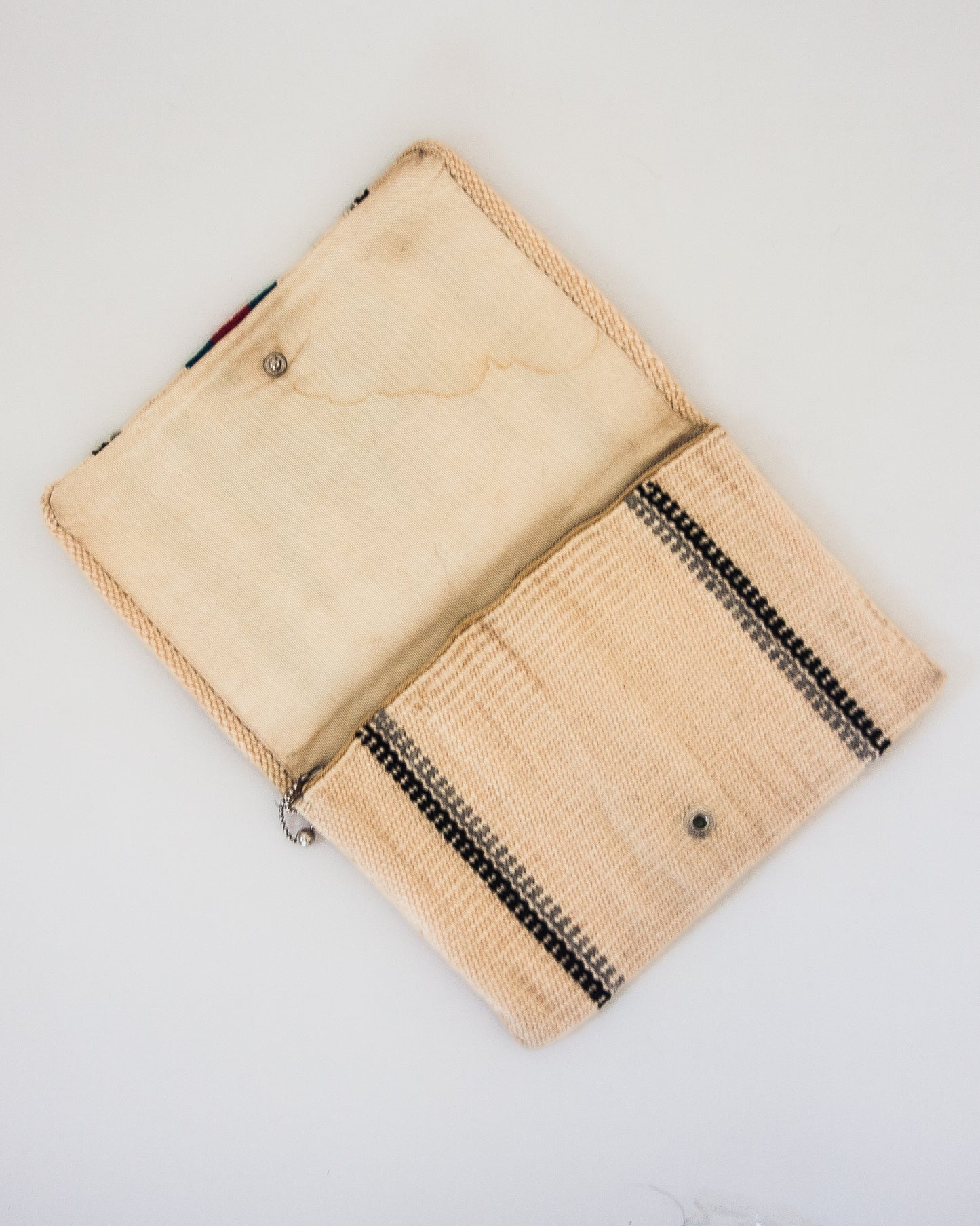 View of interior of clutch with zipper pocket and button closure.