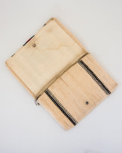 View of interior of clutch with zipper pocket and button closure.