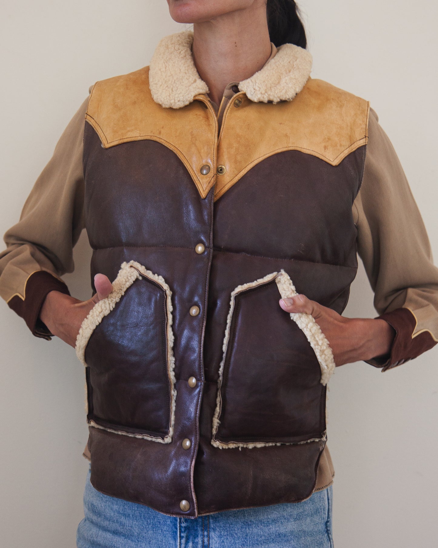 Woman wearing down leather vest with hands in pockets