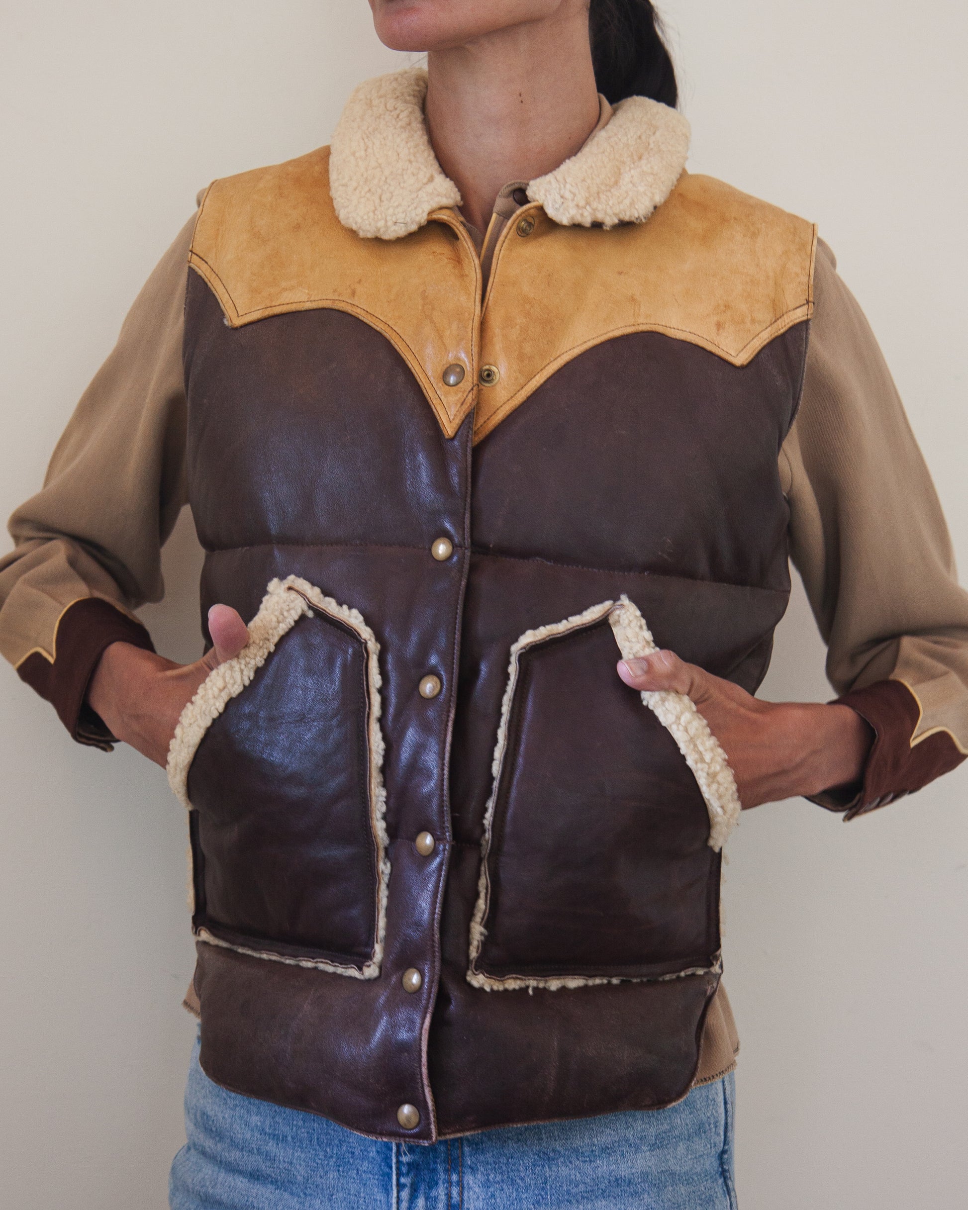 Woman wearing down leather vest with hands in pockets