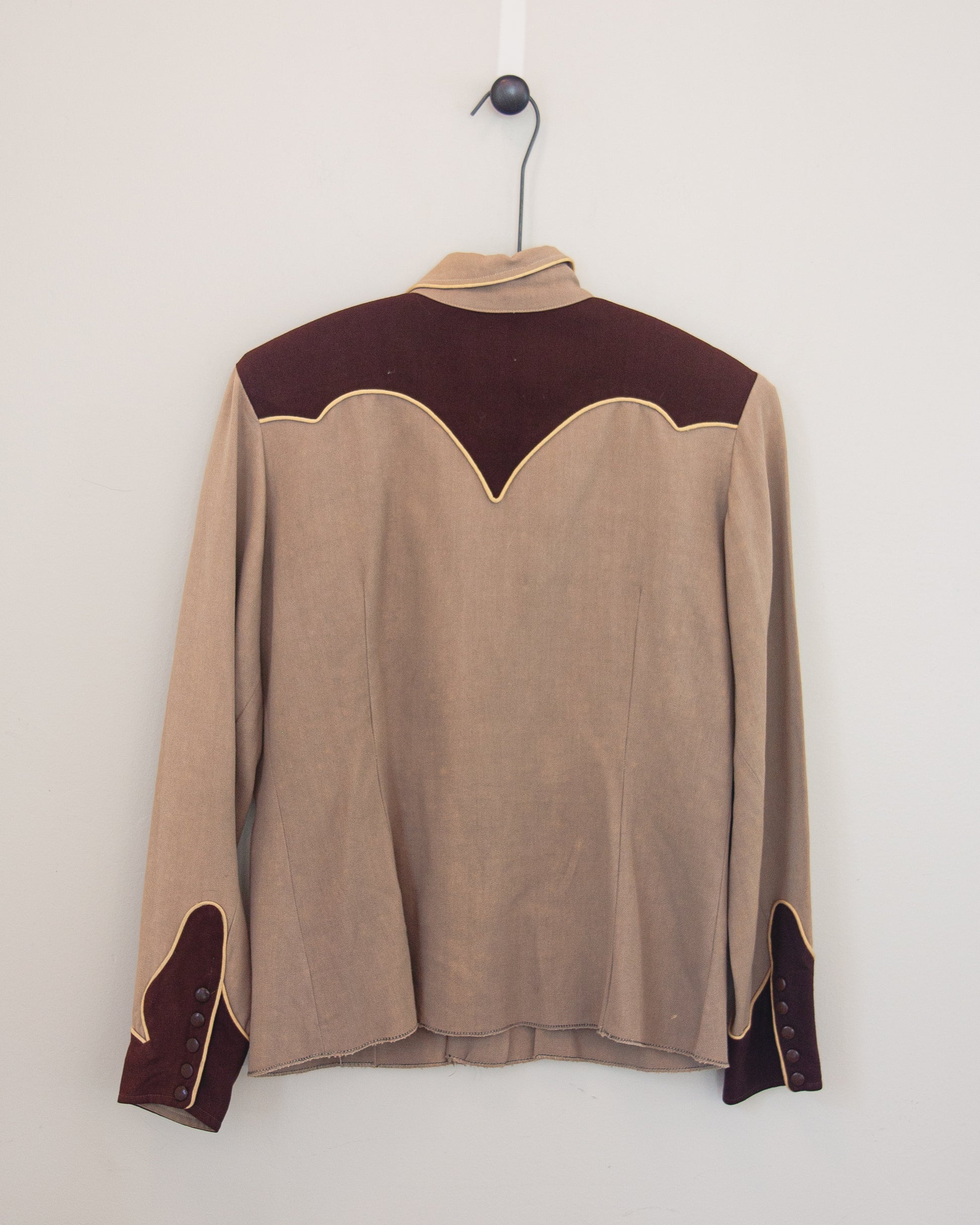 Back of tan and brown Western shirt with smile pockets on a hanger