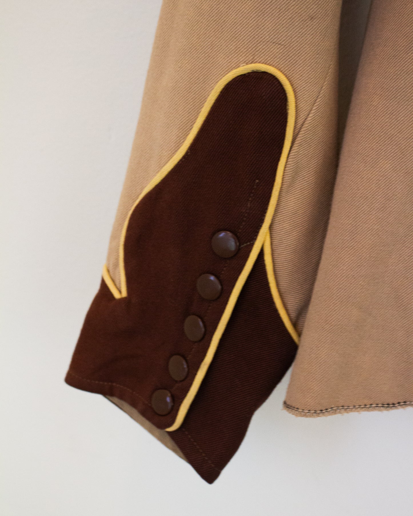 Close up view of buttons on tan and brown Western shirt with yellow trim