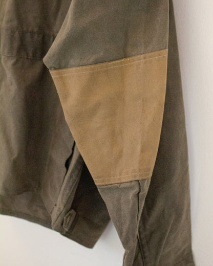 Close up of tan elbow patch on olive green jacket
