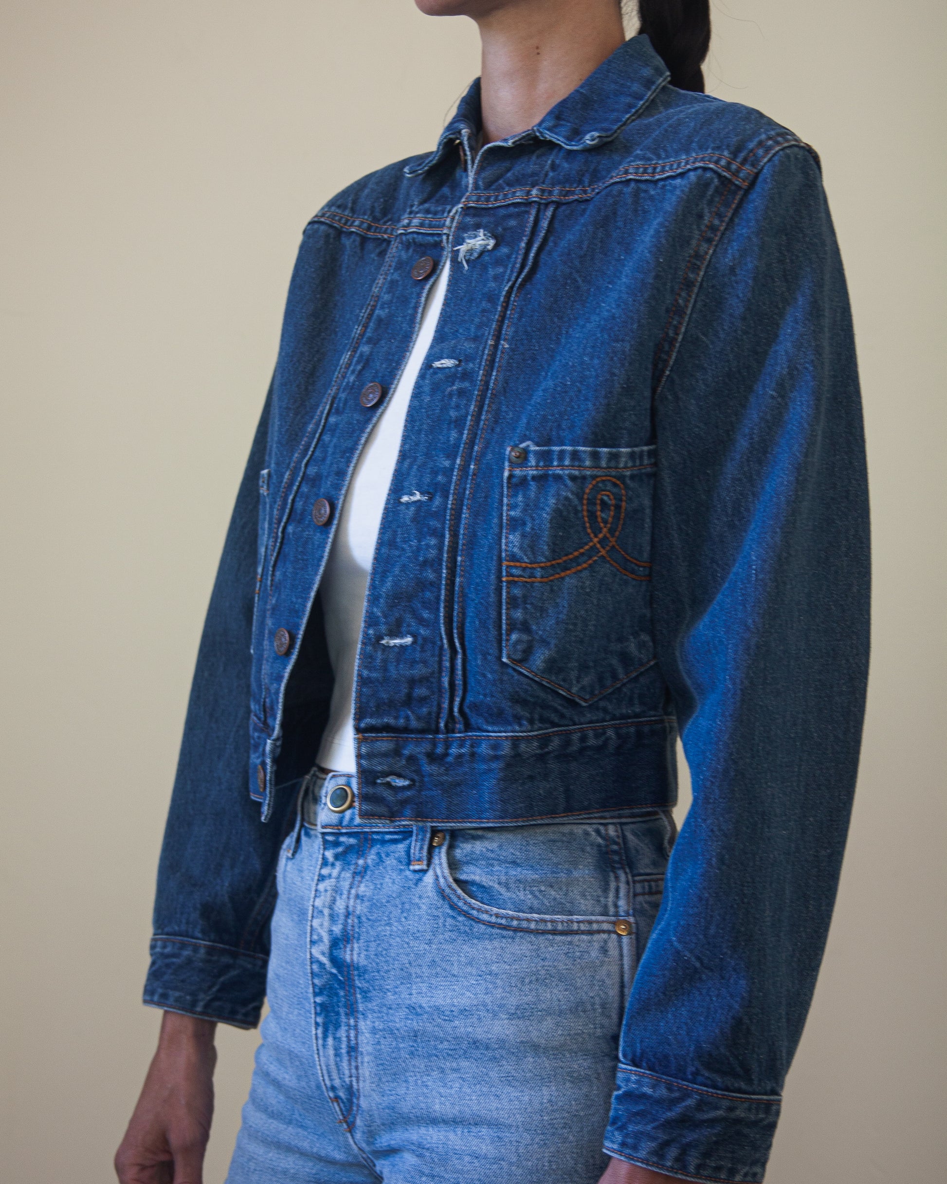 Side view of woman wearing denim jacket with white t-shirt