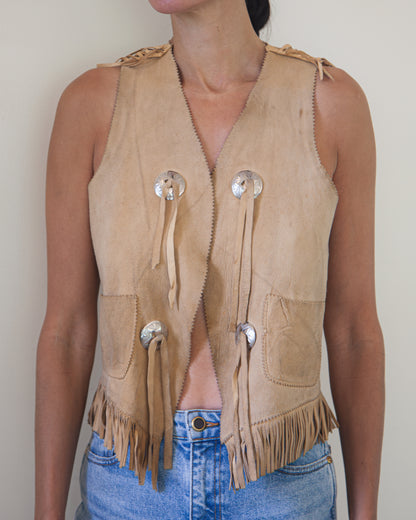 Woman wearing suede leather vest with silver buttons and leather tassels